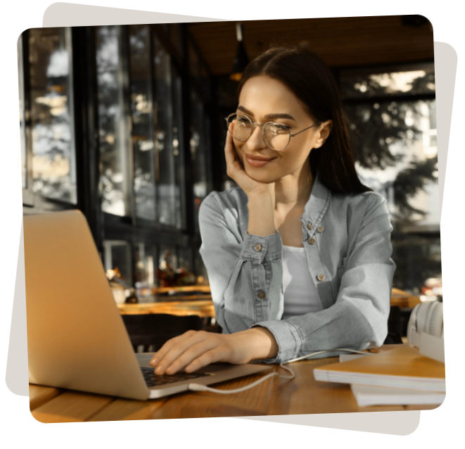 Mulher com a mão no rosto com um sorriso mexendo no computador